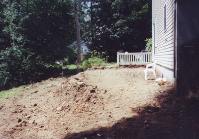 Reclaim and expand a sloping backyard and create a patio and granite wall